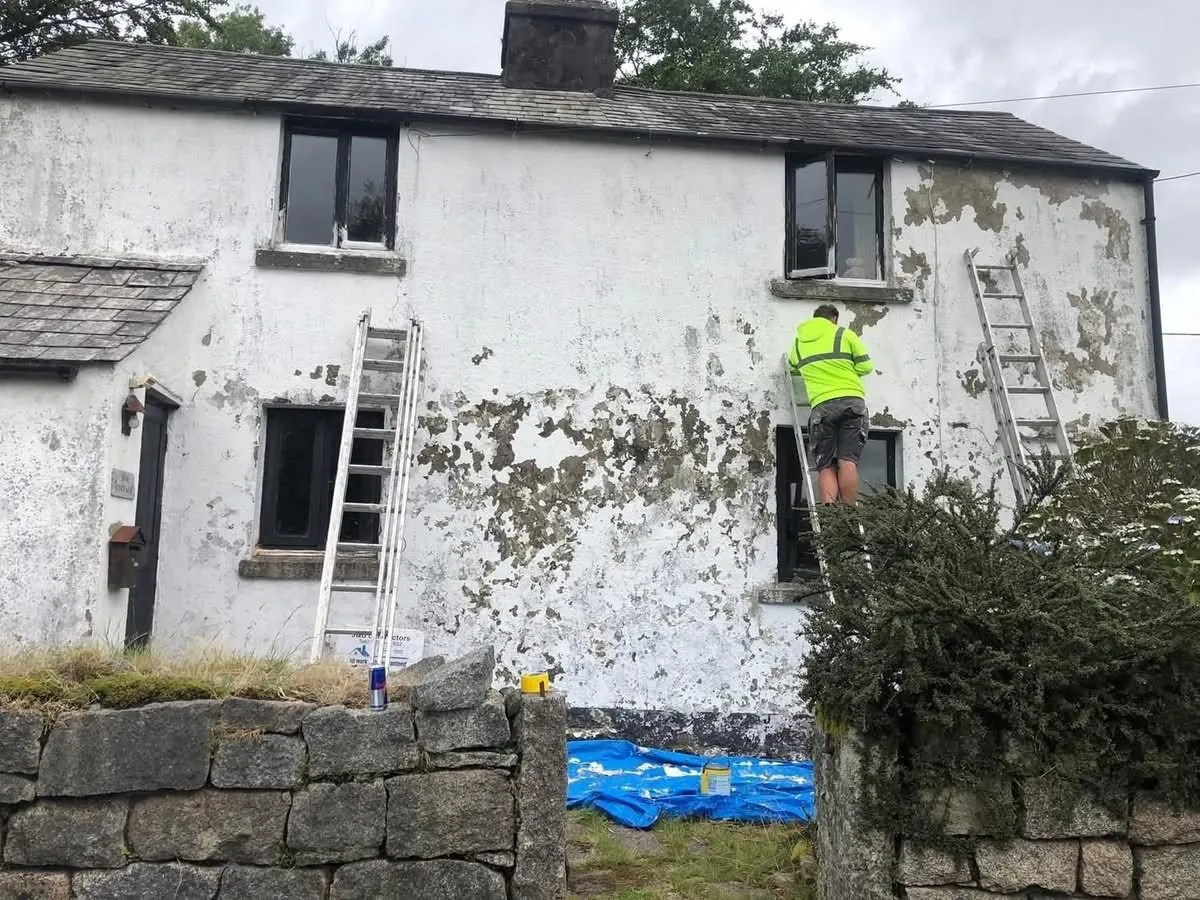 Cottage with blown, flaking render before repair in Ottery St Mary